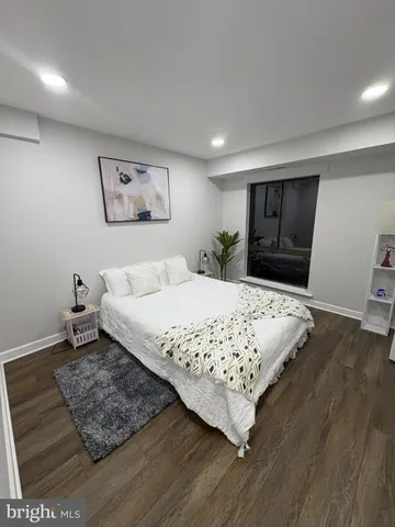 a bedroom with a bed rug and wooden floor