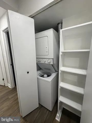 a utility room with wooden floor washer and dryer