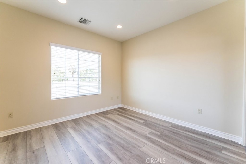 511 East Harvard Road, Unit 101 Burbank, CA 91501 - Photo 24 of 29 an empty room with wooden floor and windows