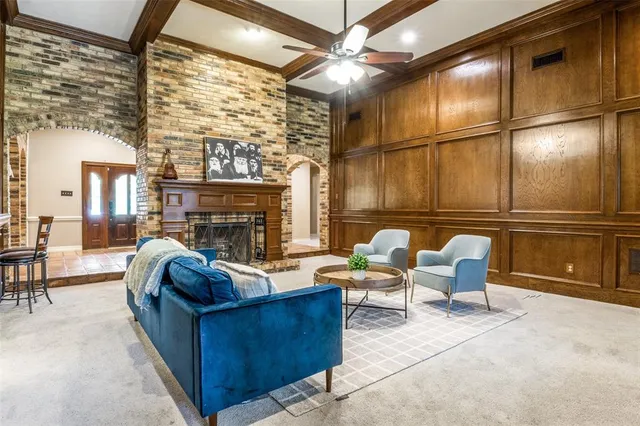 a living room with furniture a fireplace and a ceiling fan
