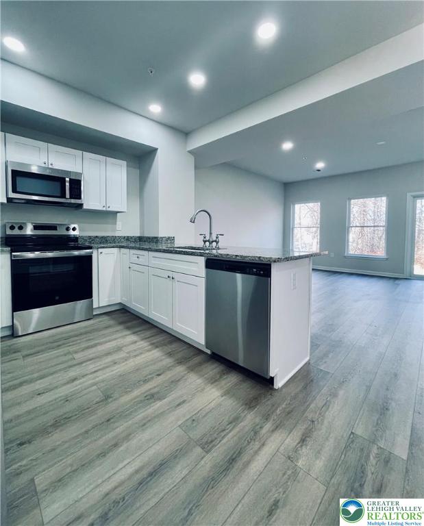 320 Barber Street, Unit LOT 32 Allentown, PA 18103 - Photo 24 of 53 a large kitchen with stainless steel appliances granite countertop a stove top oven a sink dishwasher and wooden floor