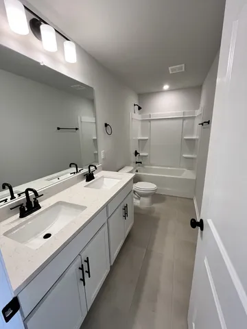 a bathroom with a double vanity sink a mirror and a shower
