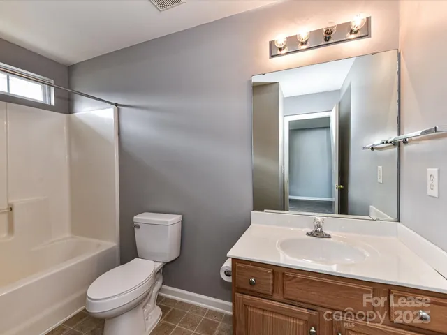a bathroom with a sink toilet a mirror and shower