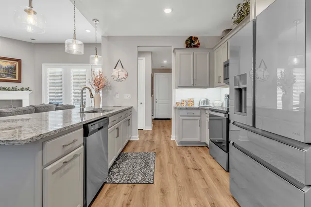 a large kitchen with granite countertop a large counter top a sink stainless steel appliances and cabinets