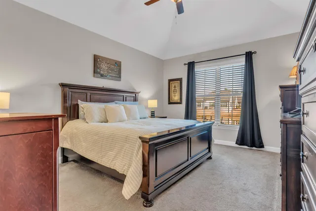 a bedroom with a bed and a flat tv screen on the dresser