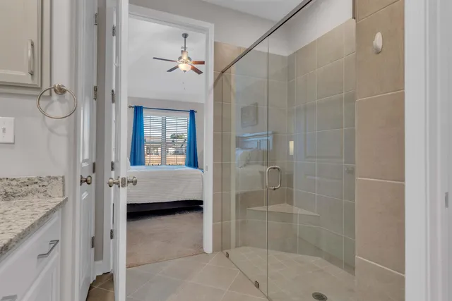 a bathroom with a granite countertop tub shower and mirror