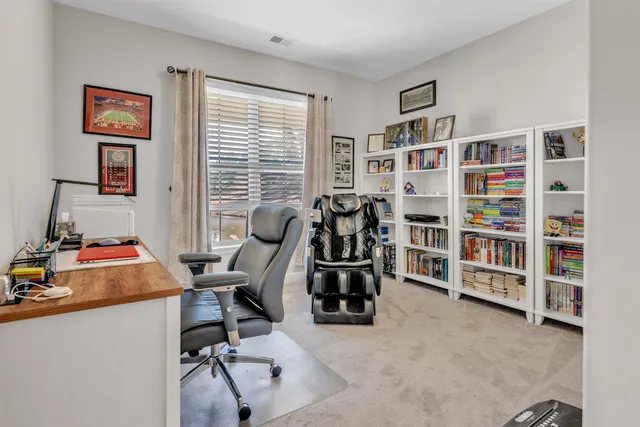 a view of a workspace with furniture and a bookshelf