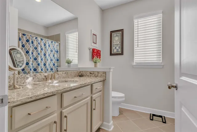 a bathroom with a granite countertop sink a toilet and a shower