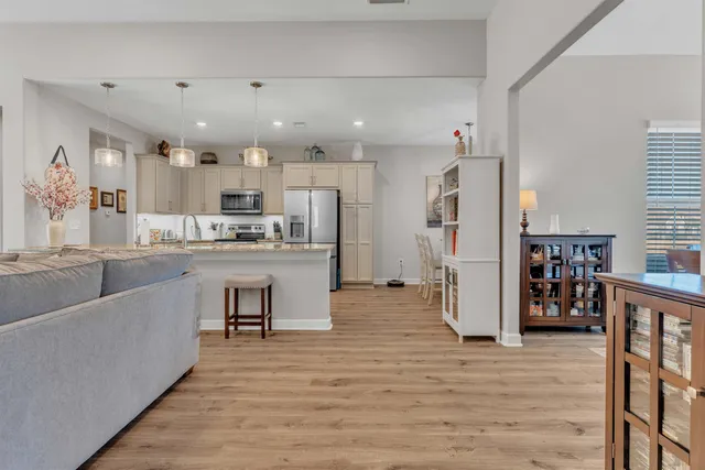 a large kitchen with stainless steel appliances kitchen island a large counter top and a view of living room