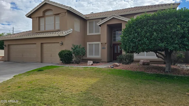 a front view of a house with a garden and plants