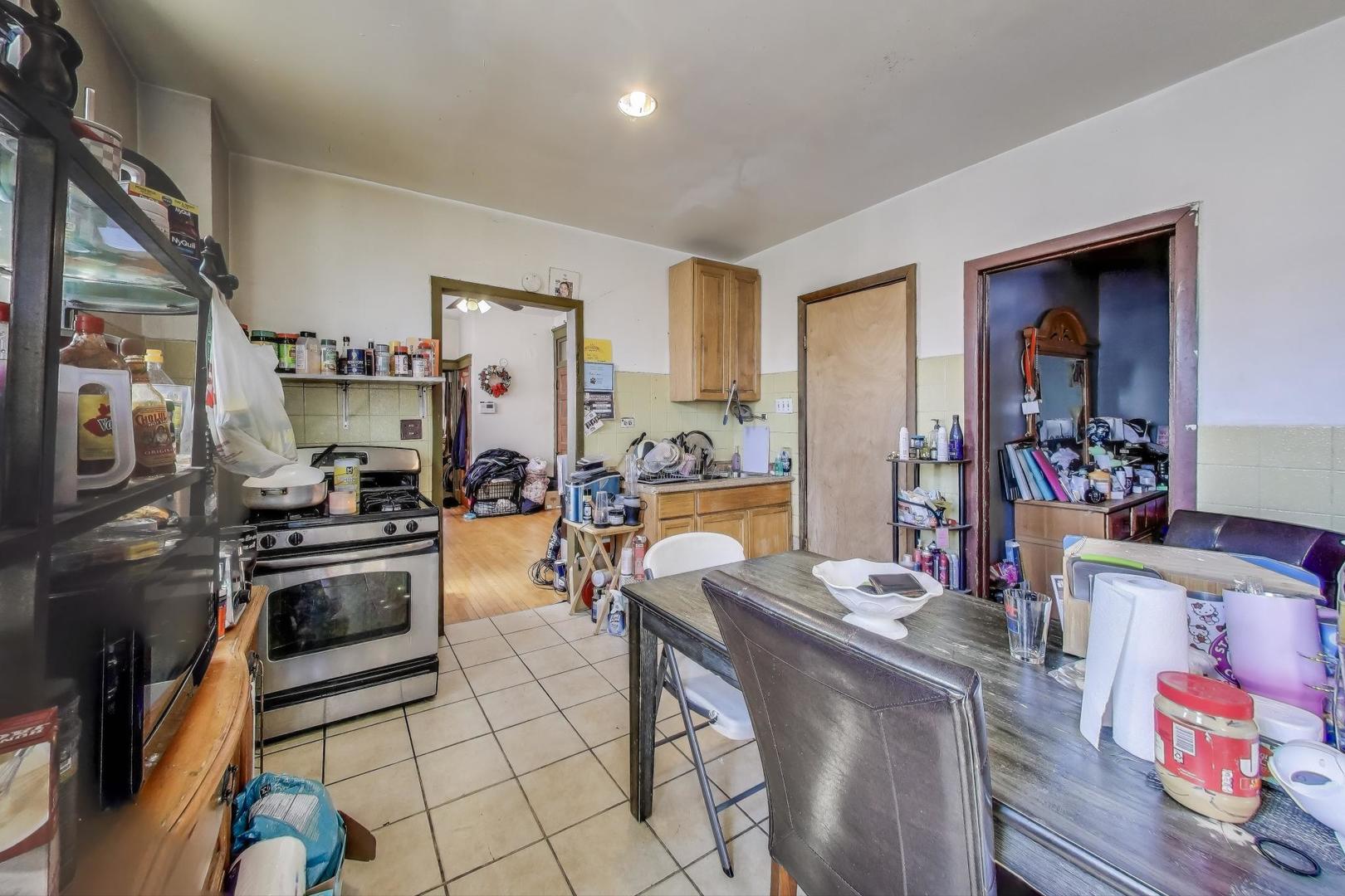 2625 South Central Park Avenue Chicago, IL 60623 - Photo 19 of 36 a kitchen with stainless steel appliances kitchen island granite countertop a stove and a refrigerator