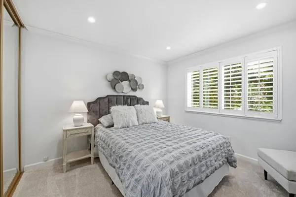a bedroom with a bed mirror and window