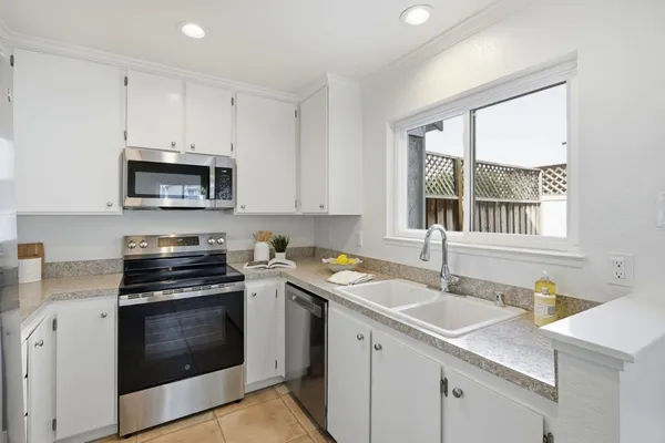 a kitchen with cabinets stainless steel appliances and a counter space