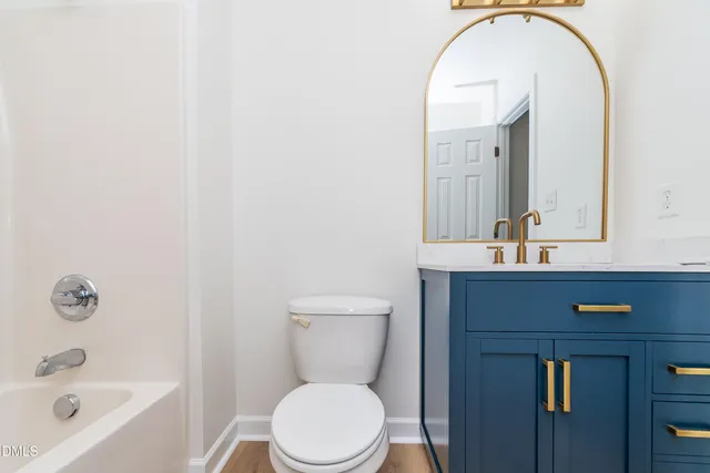 a bathroom with a toilet a sink a mirror and bathtub