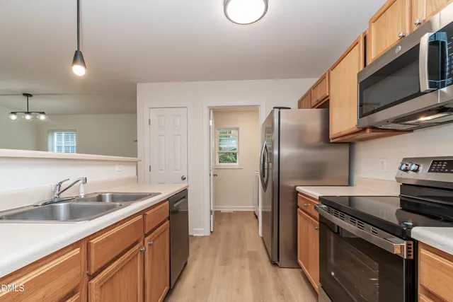 a kitchen with stainless steel appliances granite countertop a sink stove and refrigerator