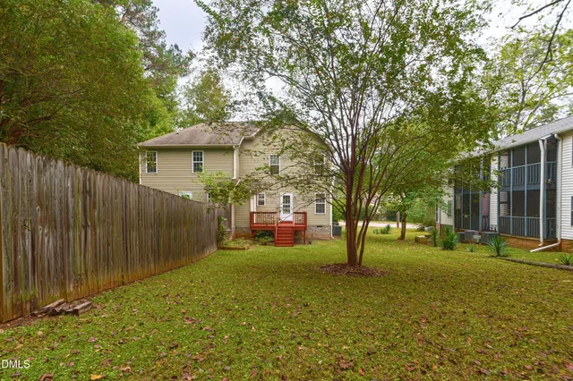 a view of a house with a yard and tree s