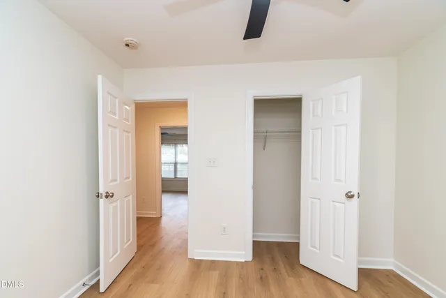 an empty room with wooden floor and closet