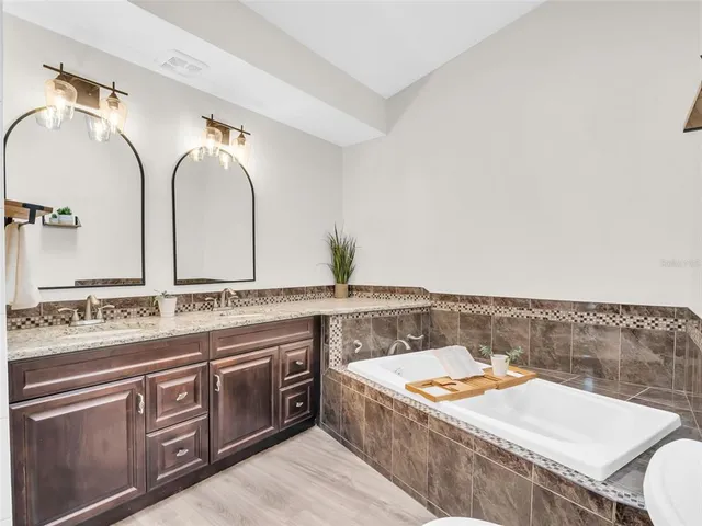 a bathroom with a granite countertop toilet a sink and a mirror