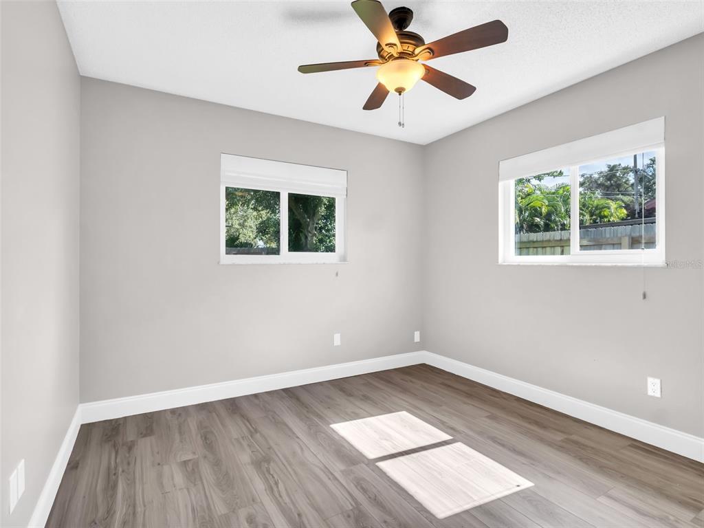 640 Kenneth Way Tarpon Springs, FL 34689 - Photo 32 of 84 an empty room with wooden floor and windows