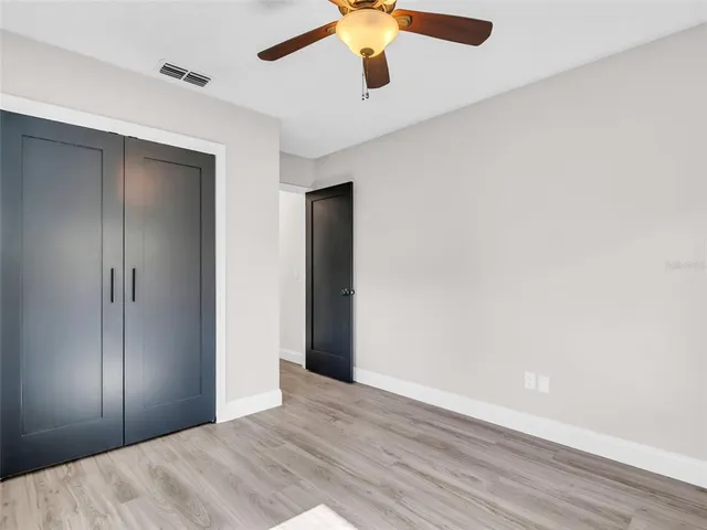 a view of a white house with a yard and potted plants