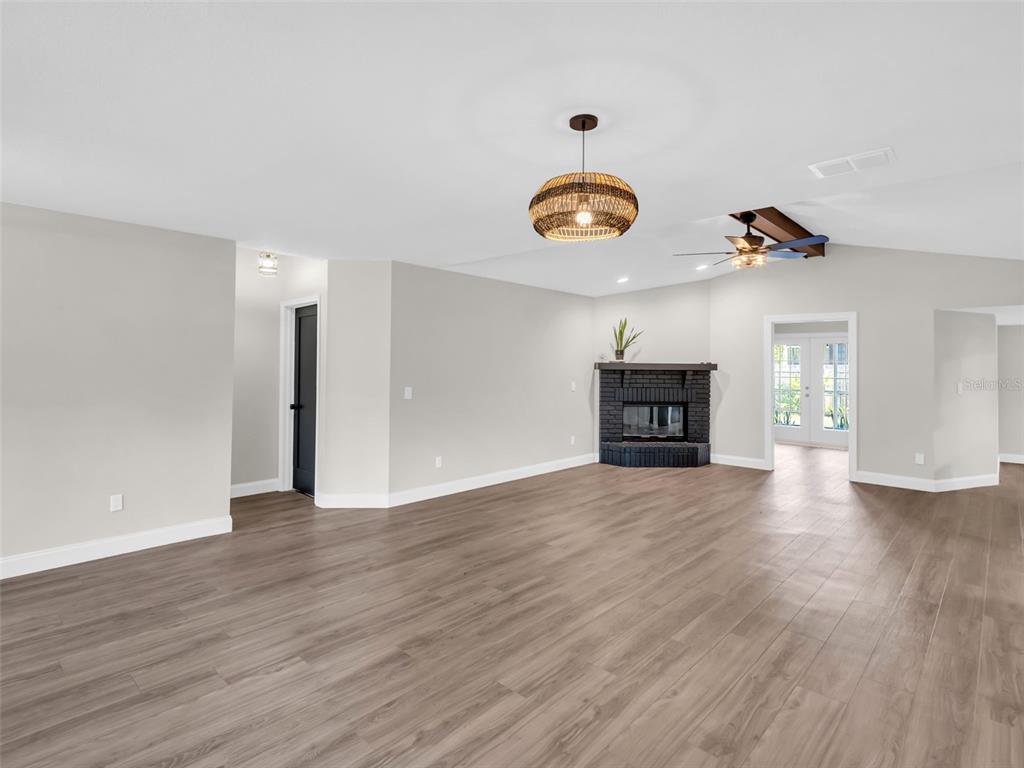 640 Kenneth Way Tarpon Springs, FL 34689 - Photo 5 of 84 an empty room with wooden floor and windows