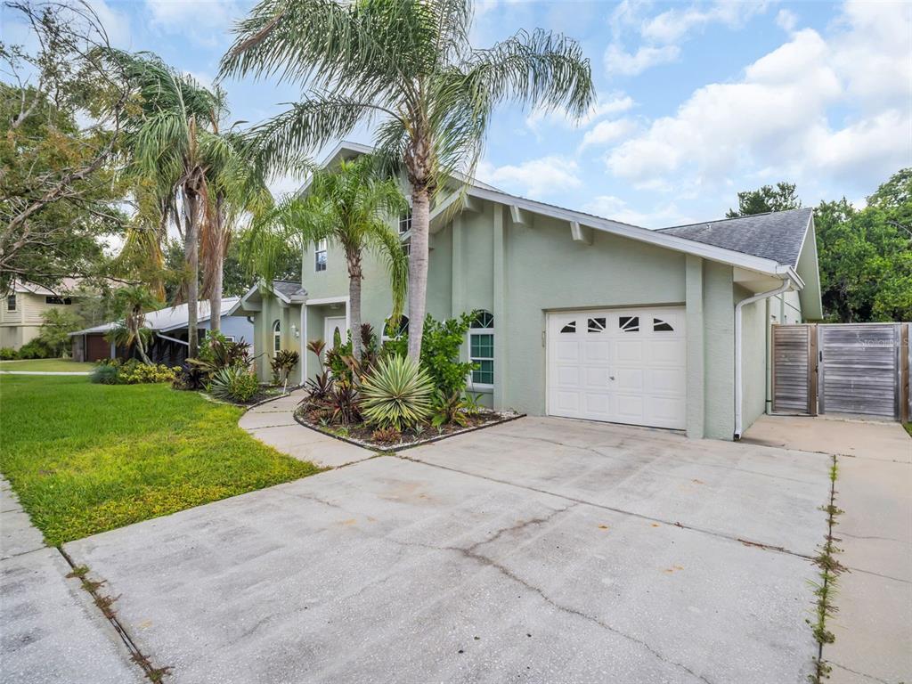640 Kenneth Way Tarpon Springs, FL 34689 - Photo 64 of 84 a view of a white house with a yard and potted plants