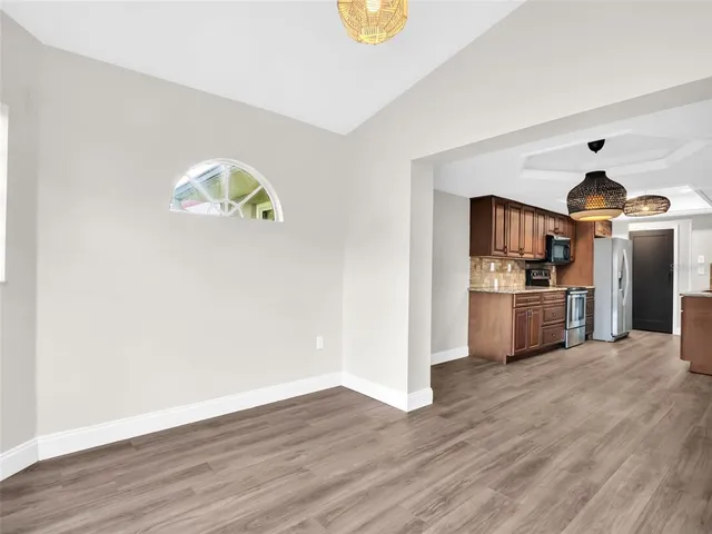 a kitchen with stainless steel appliances granite countertop a stove a sink dishwasher and a refrigerator with wooden floor