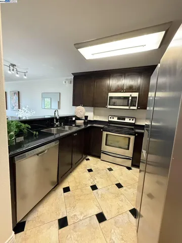 a kitchen with granite countertop a sink stainless steel appliances and a counter top