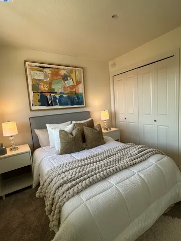 a bedroom with a bed and a painting on the wall