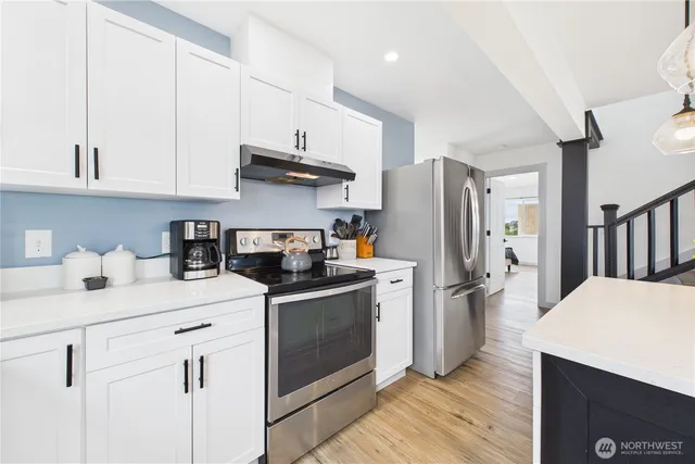 a kitchen with stainless steel appliances a stove refrigerator sink and cabinets