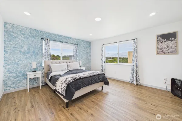 a bedroom with a bed and wooden floor