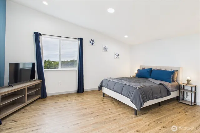 a bedroom with a bed and a flat tv screen on wall