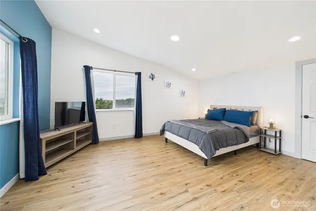 a bedroom with a bed and wooden floor