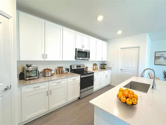 a kitchen with white cabinets and white appliances