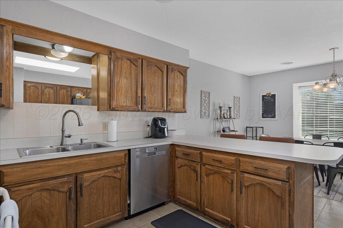 4202 Charles Street Amarillo, TX 79106 - Photo 11 of 27 a kitchen with a sink dishwasher stove and cabinets