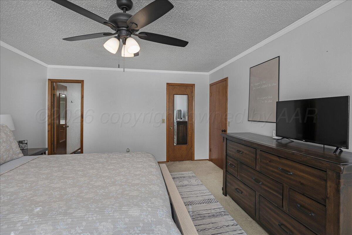 4202 Charles Street Amarillo, TX 79106 - Photo 17 of 27 a bedroom with a bed and a flat screen tv