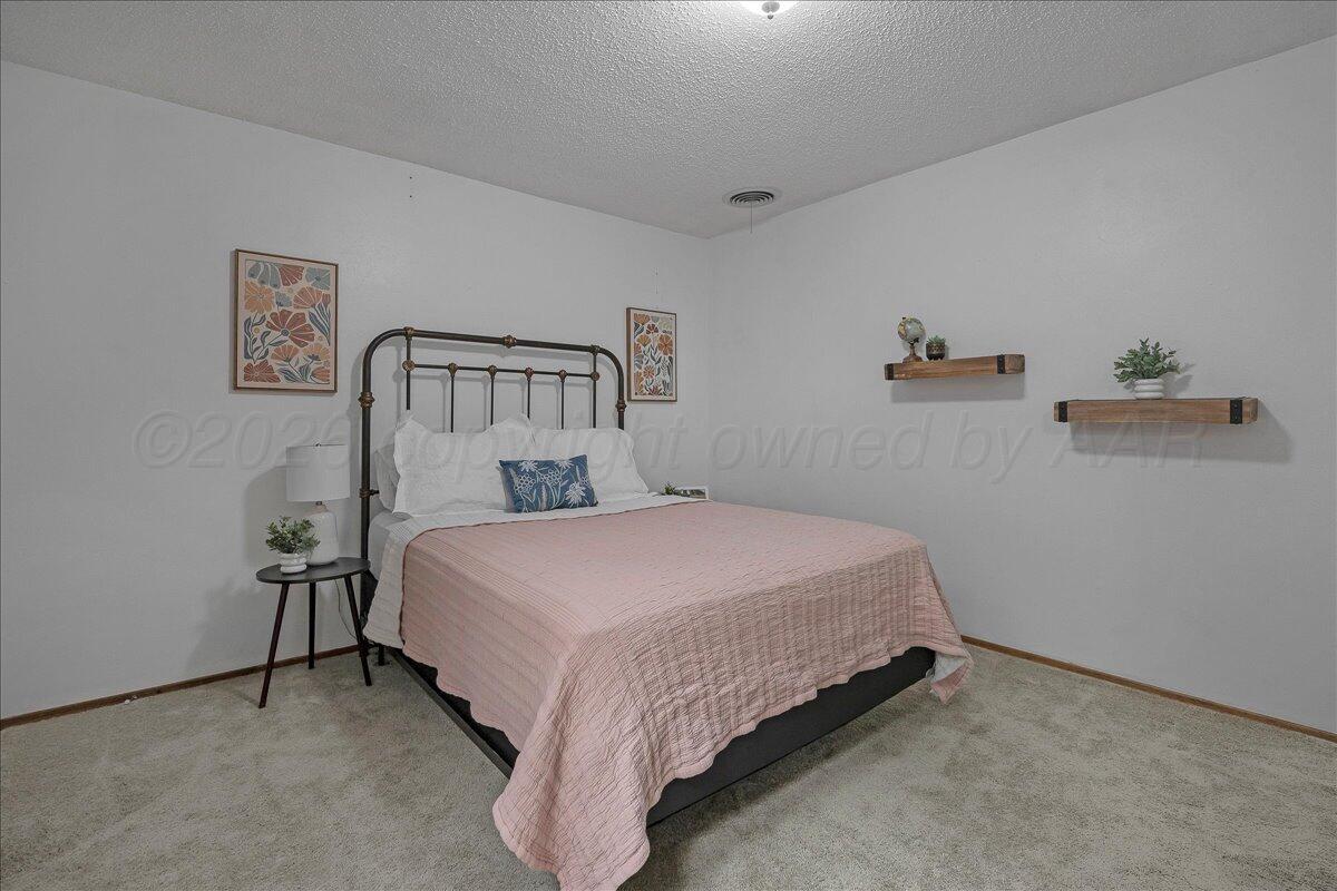 4202 Charles Street Amarillo, TX 79106 - Photo 19 of 27 a bed sitting in a bedroom next to a wall