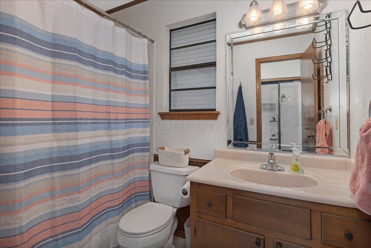 4202 Charles Street Amarillo, TX 79106 - Photo 21 of 27 a bathroom with a sink a toilet and shower