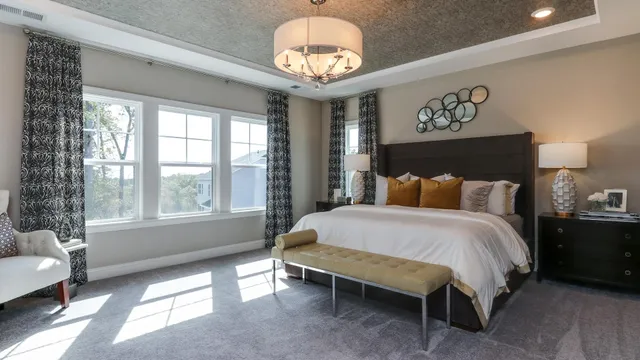 a spacious bedroom with a bed and a chandelier