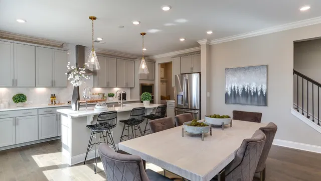 a kitchen with kitchen island a dining table and chairs