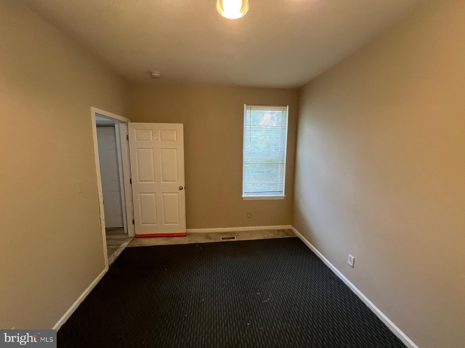 3907 Fairview Avenue Baltimore, MD 21216 - Photo 13 of 25 an empty room with wooden floor and windows