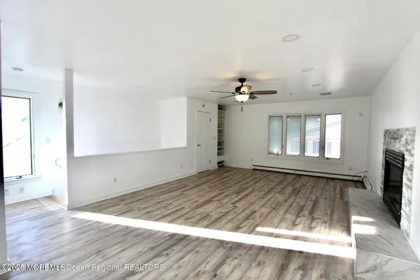 an empty room with wooden floor and fireplace