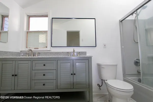 a bathroom with a granite countertop sink toilet and shower