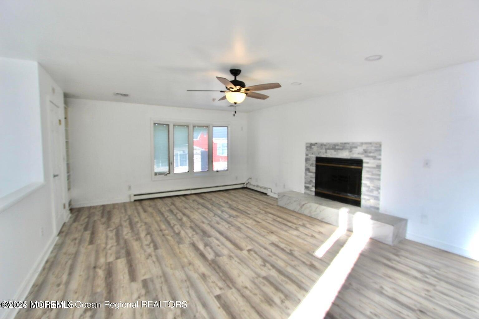 9 Kearney Street, Unit A Keyport, NJ 07735 - Photo 15 of 37 wooden floor in an empty room with a fireplace
