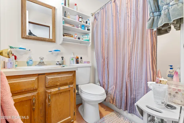 a bathroom with a sink a toilet and shower curtain