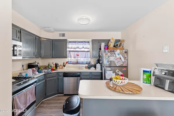 a kitchen with a sink a stove and lots of wooden cabinets