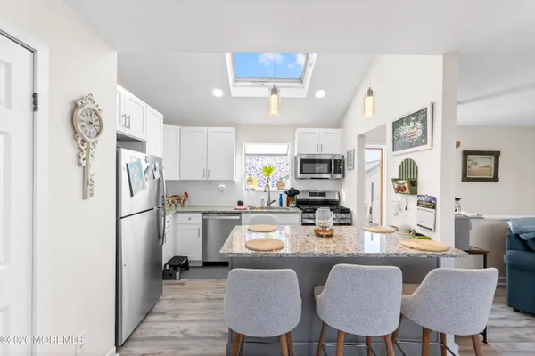 a kitchen with refrigerator and chairs