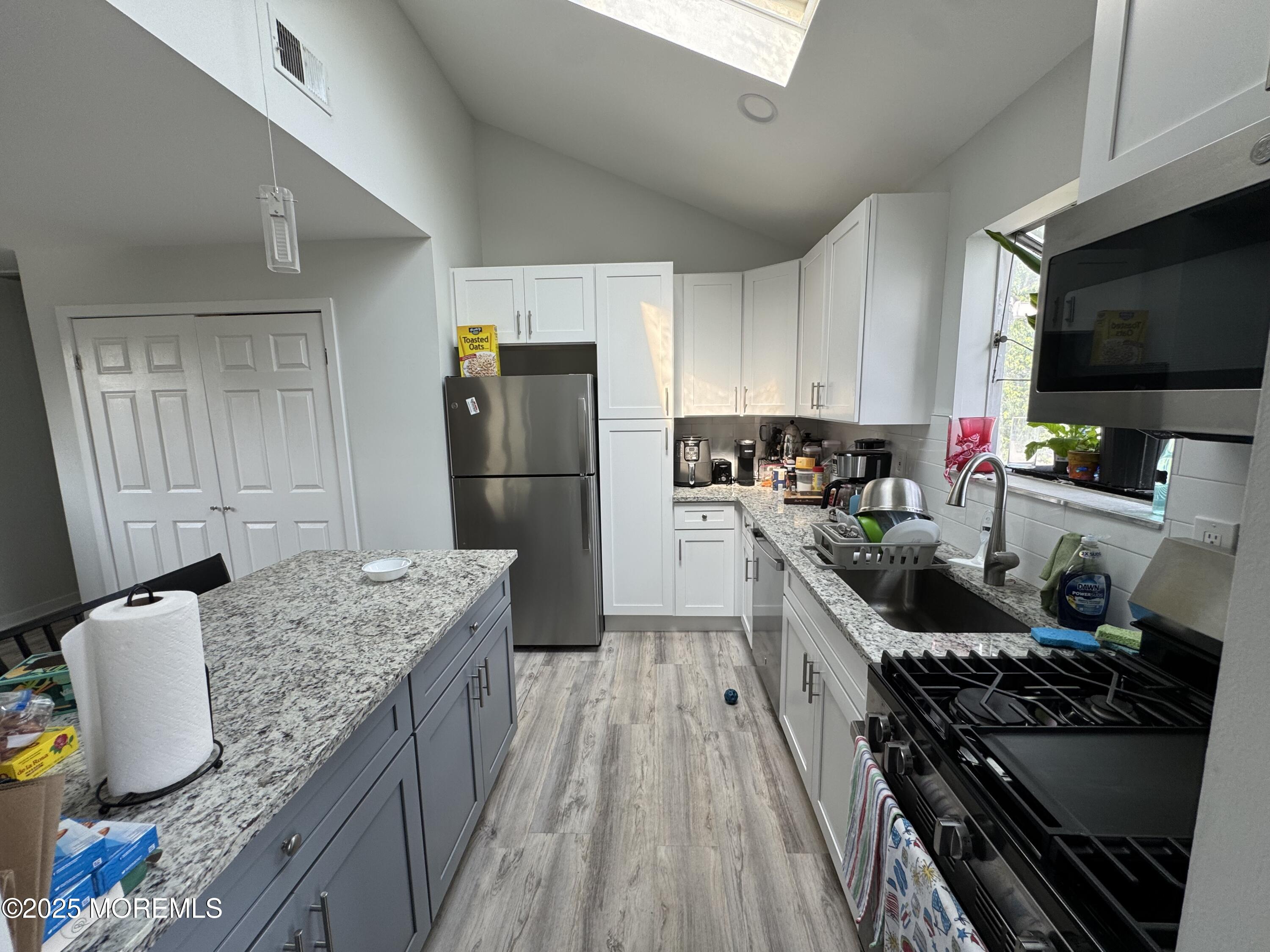 9 Kearney Street, Unit A Keyport, NJ 07735 - Photo 6 of 37 a kitchen with granite countertop kitchen island stainless steel appliances a refrigerator stove top oven and sink