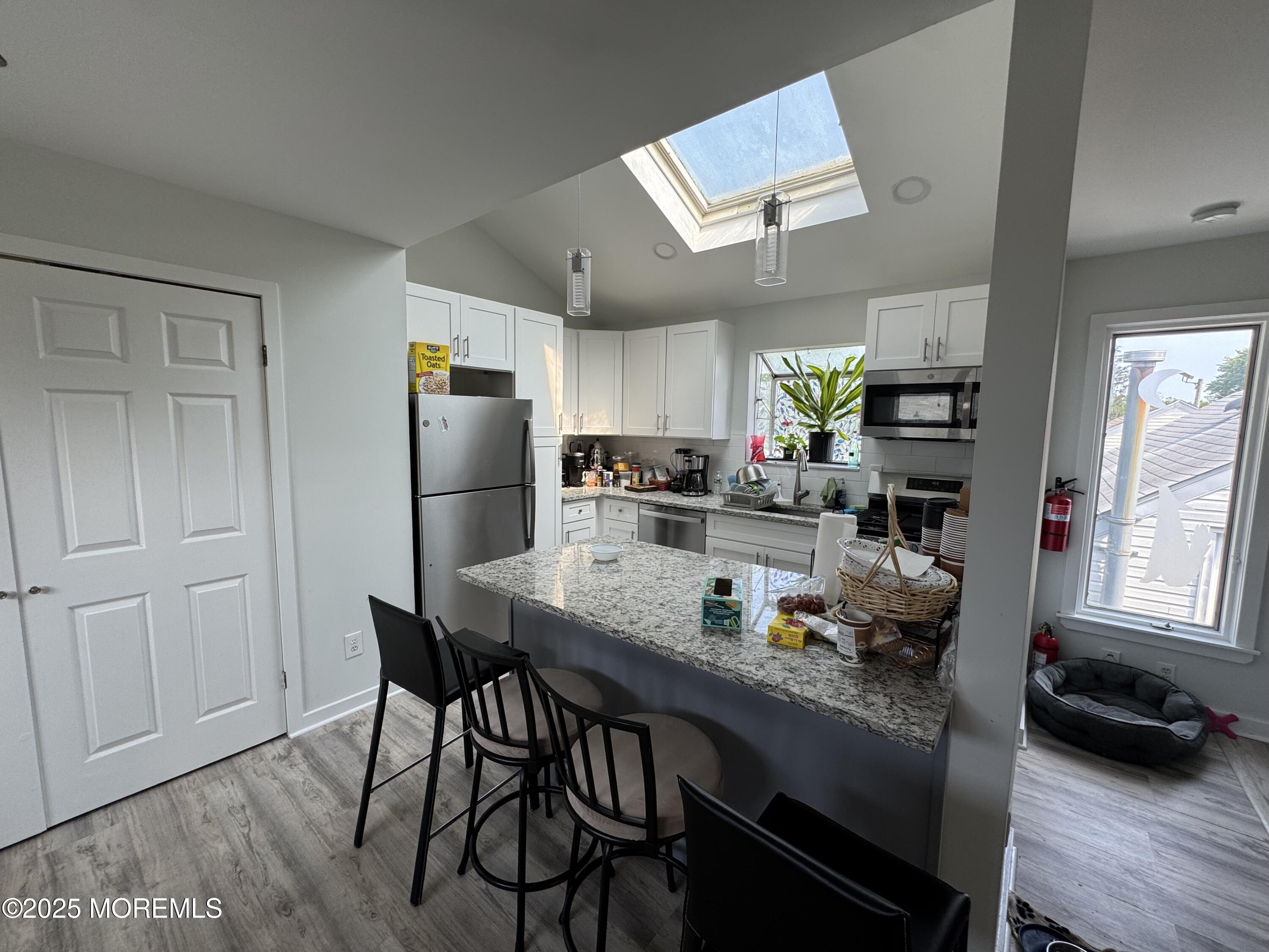 9 Kearney Street, Unit A Keyport, NJ 07735 - Photo 7 of 37 a kitchen with stainless steel appliances granite countertop table chairs refrigerator and sink