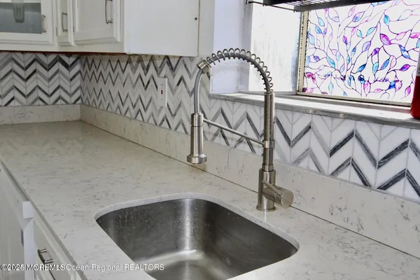 a kitchen with stainless steel appliances granite countertop table chairs refrigerator and sink